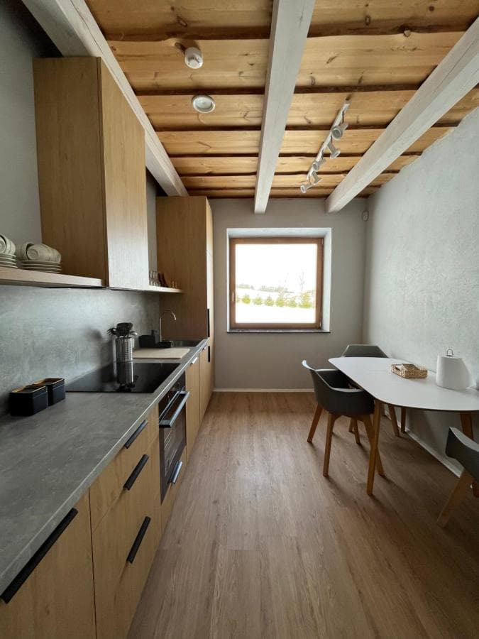 Pilnai įrengta virtuvė su ąžuolo spalvos baldais ir moderniu židiniu