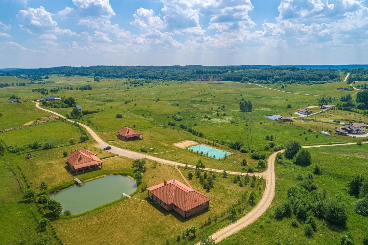 Kaimo kraštovaizdis su ežerais tolumoje, pieva ir svečių namais