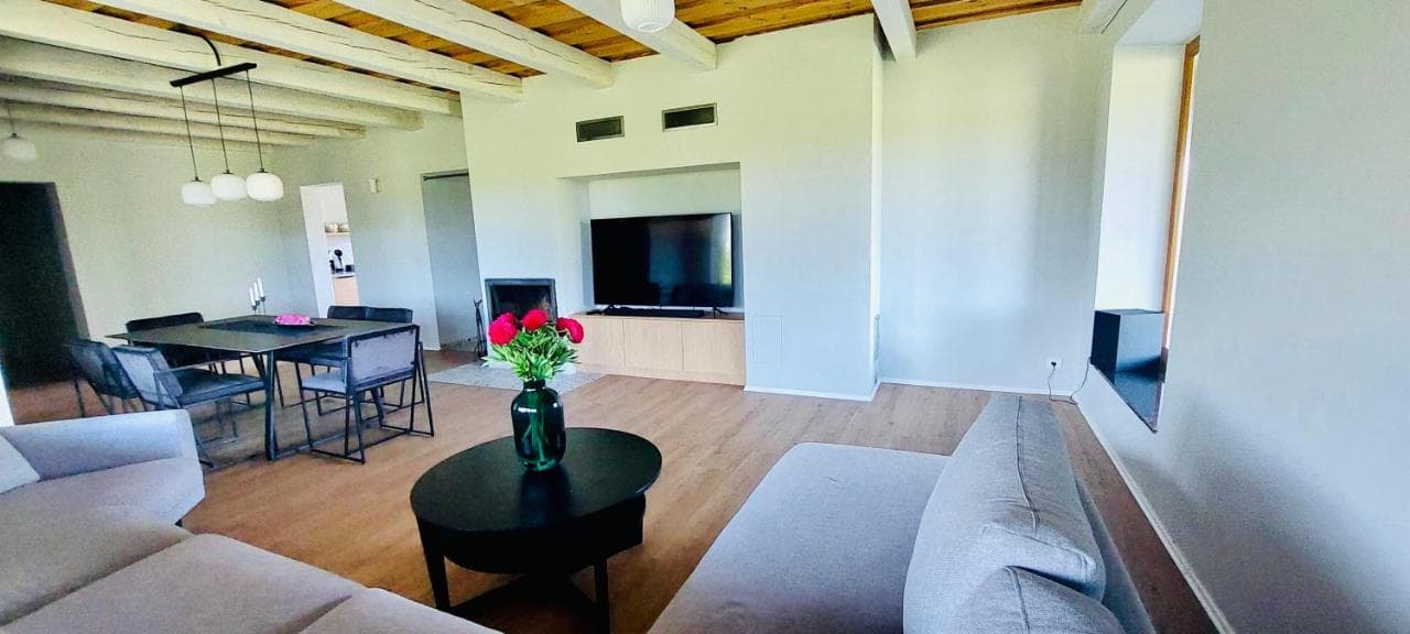 Bendra erdvė su svetaine, valgomuoju ir panoraminiais langais