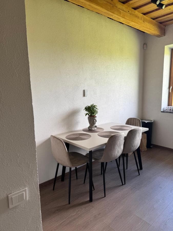 Bendra erdvė su svetaine, valgomuoju ir panoraminiais langais